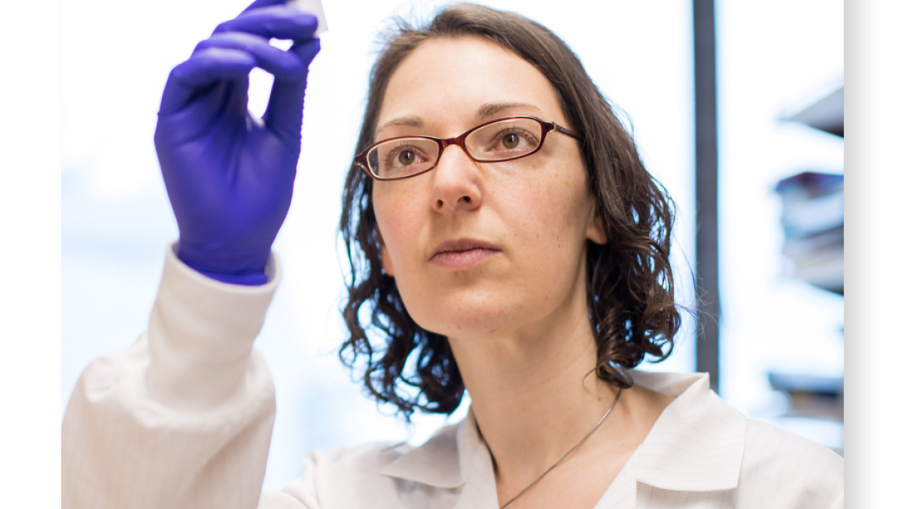 Researcher looking at vial
